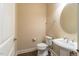 Powder room featuring a pedestal sink, and a round decorative mirror above at 2620 Club Level Dr, Apex, NC 27523