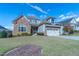 Charming two-story home with stone accents, lush lawn, two-car garage, and beautiful curb appeal at 2620 Club Level Dr, Apex, NC 27523