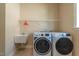 Bright laundry room with a utility sink and modern washer/dryer, perfect for efficient chores at 2620 Club Level Dr, Apex, NC 27523