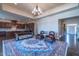 Elegant living room with chandelier, leather seating, and a large patterned rug at 2620 Club Level Dr, Apex, NC 27523