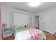 Bright bedroom with wood floors, green and pink bedding, and white walls at 2808 Newquay St, Durham, NC 27705