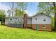 Rear exterior view of the home featuring a deck, brick chimney, and access to the basement at 2808 Newquay St, Durham, NC 27705