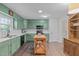 Bright kitchen featuring green cabinets, white countertops, black appliances, and wood breakfast island at 2808 Newquay St, Durham, NC 27705