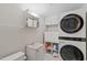 Laundry room with modern stacked washer and dryer, utility sink, and storage at 2808 Newquay St, Durham, NC 27705