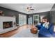 Cozy living room features a painted fireplace, hardwood floors, and a bright doorway leading outside at 2808 Newquay St, Durham, NC 27705