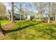 Large grassy backyard features mature trees, a wood fence, and a view of the home's deck and screened porch at 2868 Anfield Rd, Raleigh, NC 27606