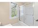 Shower with sliding glass doors and window with natural light in an airy bathroom at 2868 Anfield Rd, Raleigh, NC 27606