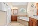 Bathroom featuring a soaking tub, and vanity cabinets with granite countertops at 2868 Anfield Rd, Raleigh, NC 27606