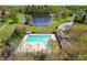 Aerial view of the community pool, bath house, lake, and parking, all surrounded by lush greenery at 2868 Anfield Rd, Raleigh, NC 27606