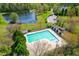 Overhead view of the community pool, lake, and bath house in a verdant setting with mature trees at 2868 Anfield Rd, Raleigh, NC 27606