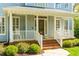 Charming front porch features detailed columns, a rocking chair, and fresh landscaping at 2868 Anfield Rd, Raleigh, NC 27606