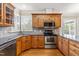 Well-equipped kitchen with stainless steel appliances, wooden cabinetry and granite countertops at 2868 Anfield Rd, Raleigh, NC 27606