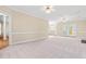 Spacious living room with neutral carpeting, bright windows and adjacent dining area at 2868 Anfield Rd, Raleigh, NC 27606