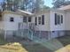 Rear exterior with steps, shows the foundation, windows with black shutters, and exterior siding at 307 Watson St, Creedmoor, NC 27522