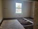 Bedroom needing renovation with bare subfloor and natural light from a large window at 307 Watson St, Creedmoor, NC 27522