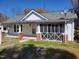 Charming home featuring white siding, a gray roof, a cozy screened-in porch, and classic architectural details at 307 Watson St, Creedmoor, NC 27522