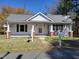 Modest home with a covered front porch, featuring a gray roof, white siding, and classic black shutters at 307 Watson St, Creedmoor, NC 27522