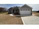 Charming single-story home with a two-car garage, covered porch, and newly installed gray siding at 32 Tanseyleaf Dr, Smithfield, NC 27577