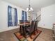 Bright dining room features a modern table with seating for four beneath a decorative chandelier at 329 Chamberlain Dr, Clayton, NC 27527