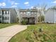 Two-story home with a long concrete driveway, well-manicured lawn, and lush green landscaping at 329 Chamberlain Dr, Clayton, NC 27527