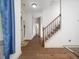 Hallway features hardwood floors, staircase with black iron spindles and entry to full bathroom at 329 Chamberlain Dr, Clayton, NC 27527