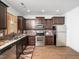Kitchen features stainless steel appliances, dark wood cabinets, granite countertops, and decorative backsplash at 329 Chamberlain Dr, Clayton, NC 27527