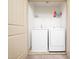 Bright laundry room features a white washer and dryer, plus a shelf for storage at 329 Chamberlain Dr, Clayton, NC 27527