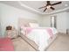 Bright main bedroom with tray ceiling and carpeted floors, features a bedside table at 329 Chamberlain Dr, Clayton, NC 27527