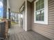 Inviting covered porch with stone accents and dark wood flooring, offering a relaxing outdoor space at 329 Chamberlain Dr, Clayton, NC 27527