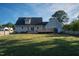 Large backyard with a deck, shed, fence, and green grass, providing ample space at 35 Fairway Ct, Dunn, NC 28334