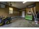 Spacious garage, featuring a lawn mower, toolbox, shelves, and a rollup door at 35 Fairway Ct, Dunn, NC 28334