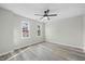 A bright bedroom features two windows, stylish flooring and a ceiling fan at 3717 Phillips W Way, Durham, NC 27713