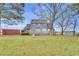 Expansive backyard featuring a blue home with a wooden deck, mature trees, and plenty of open space at 3808 Johnson Pond Rd, Apex, NC 27539