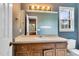 Bathroom with a window, wood vanity, soft countertop, and unique blue wallpaper at 3808 Johnson Pond Rd, Apex, NC 27539