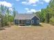 Back exterior view of home featuring a cozy screened porch and well-manicured lawn at 390 Pilot Ridge Rd, Zebulon, NC 27597