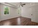 Bright bedroom with two large windows providing ample natural light, a ceiling fan, and warm wood flooring at 390 Pilot Ridge Rd, Zebulon, NC 27597