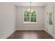 Inviting dining room featuring a modern chandelier, a large window with a view, and warm wood floors at 390 Pilot Ridge Rd, Zebulon, NC 27597
