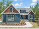 Charming home with a blue exterior, wooden accents, and well-maintained landscaping at 390 Pilot Ridge Rd, Zebulon, NC 27597