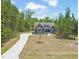 Front exterior view of charming home with well-kept lawn and tree-lined background at 390 Pilot Ridge Rd, Zebulon, NC 27597