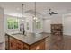 Modern kitchen featuring a spacious island with a sink, stylish pendant lighting, and an open view of the fireplace at 390 Pilot Ridge Rd, Zebulon, NC 27597