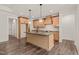 Well-lit kitchen featuring wooden cabinets, a center island, and stainless steel appliances at 390 Pilot Ridge Rd, Zebulon, NC 27597