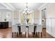 Well-lit dining room with dark wood table, white chairs, wood floors, and wainscoting at 4121 Enfield Ridge Dr, Cary, NC 27519