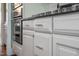 Modern kitchen with stainless steel oven, white cabinets and drawers with brushed bronze hardware at 4121 Enfield Ridge Dr, Cary, NC 27519