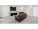 Cozy living room features leather couches, media center and mounted TV, creating inviting place at 4121 Enfield Ridge Dr, Cary, NC 27519