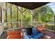 Covered porch featuring a fire pit and seating, creating an inviting outdoor space with serene views of the surrounding trees at 4121 Enfield Ridge Dr, Cary, NC 27519