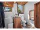 Bright bathroom with wood vanity, toilet, window, and washing machine at 4401 E L G Rd, Efland, NC 27243
