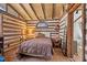 Rustic bedroom featuring log walls, wood flooring, and cozy decor, offering a serene and unique ambiance at 4401 E L G Rd, Efland, NC 27243