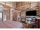 Rustic bedroom with log walls, wooden floors, and cozy furnishings with a bed, and a view to the home beyond at 4401 E L G Rd, Efland, NC 27243