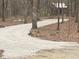 Winding gravel driveway leading through a serene wooded area to the property at 4401 E L G Rd, Efland, NC 27243
