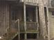 Inviting entrance featuring a classic wooden door and cozy porch, blending seamlessly with the wooded surroundings at 4401 E L G Rd, Efland, NC 27243
